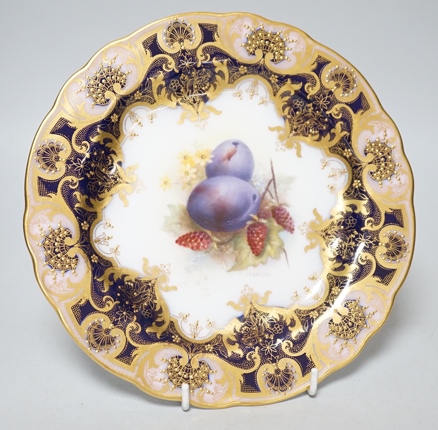 A Royal Worcester plate painted with fruit and berries by R. Sebright, signed, under a blue and gilt ground, date mark 1918